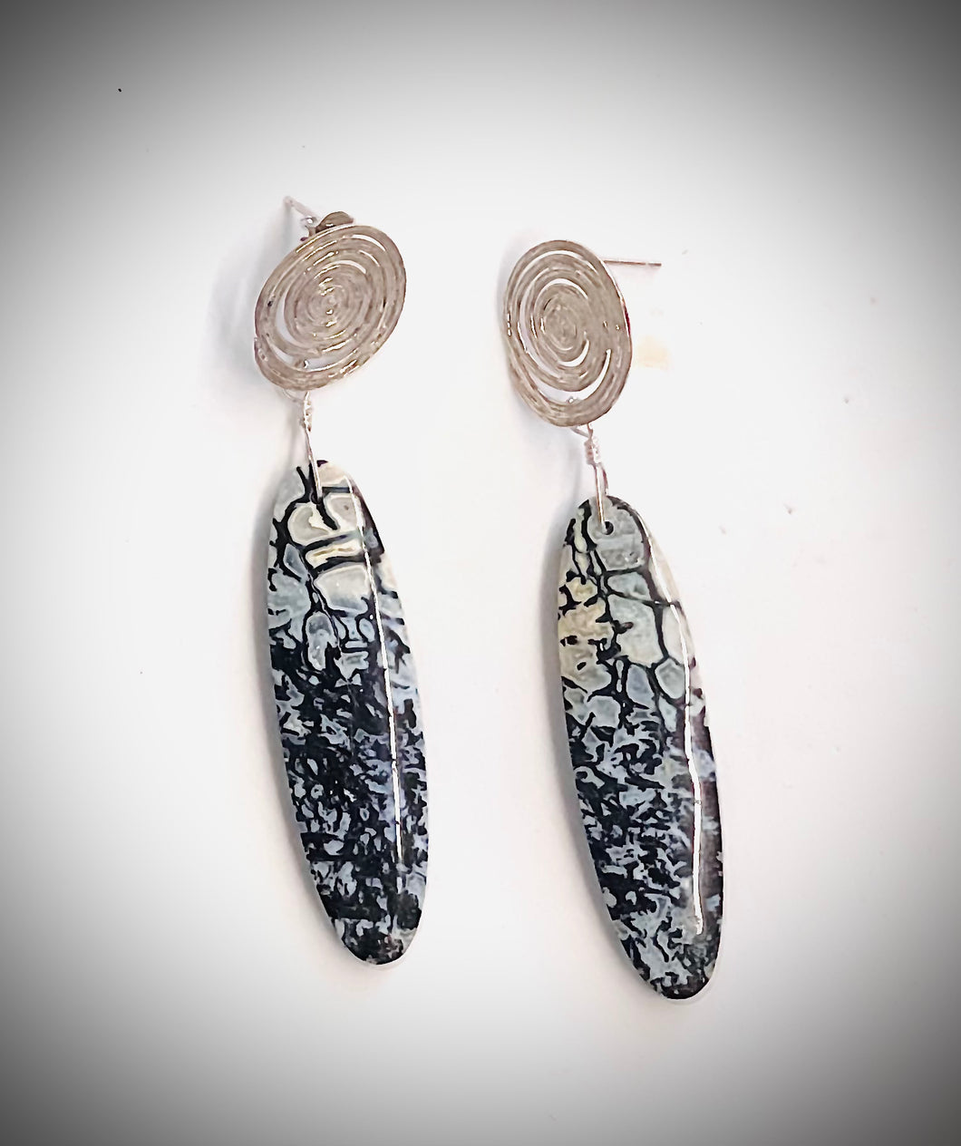 Earrings with long black petrified beads