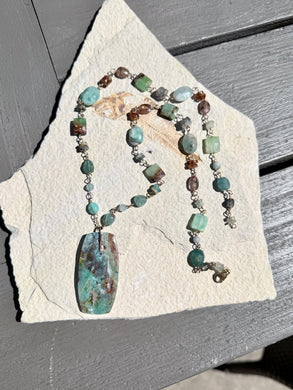 Necklace with light colors petrified opalized wood and various stones