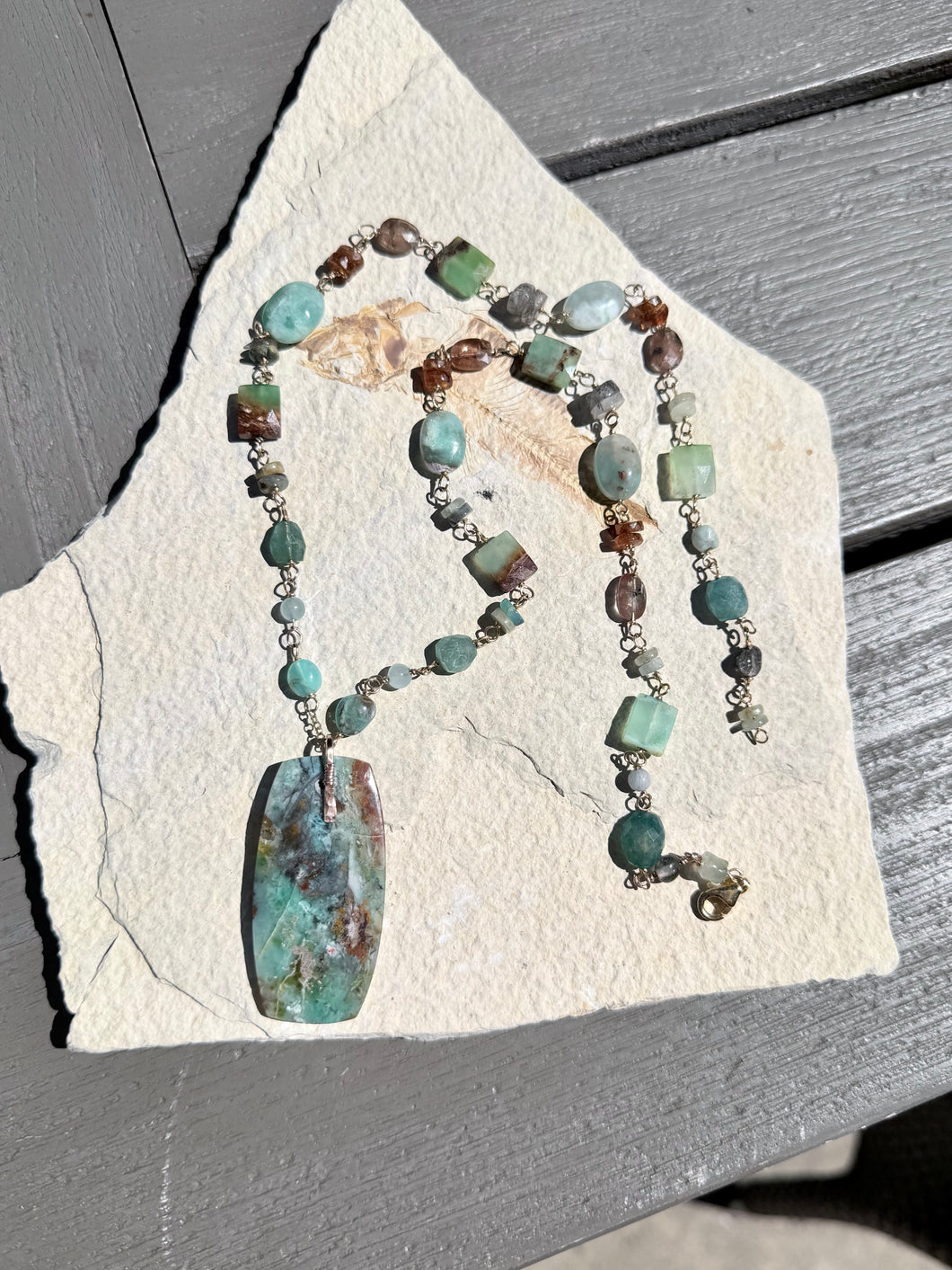 Necklace with light colors petrified opalized wood and various stones